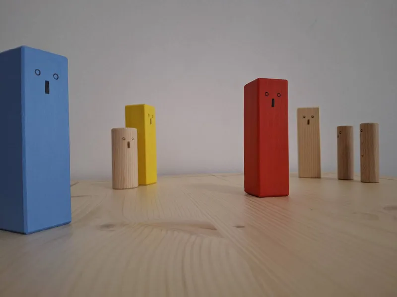 Holzbrett mit verschiedenfarbigen Holzfiguren. Figuren sehen in unterschiedliche Richtungen.