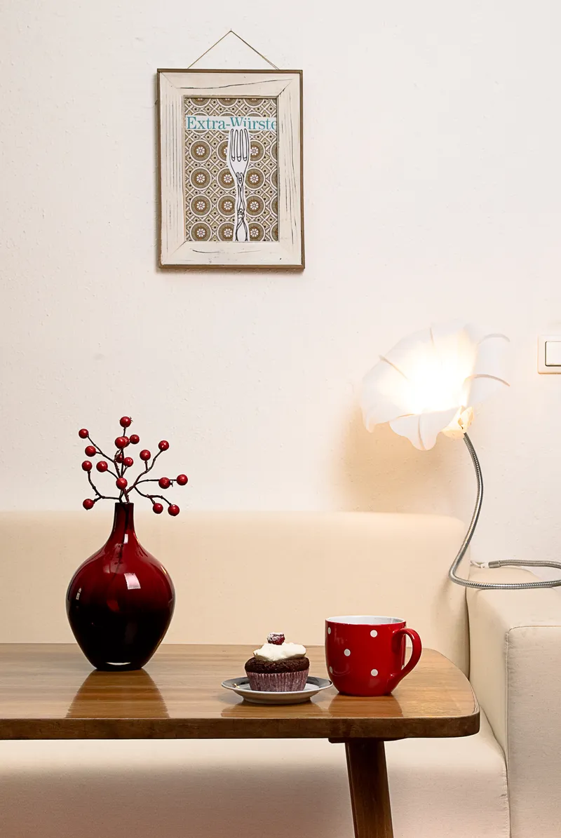 Ein Tisch im Therapiecafé. Auf dem Tisch stehen ein Kaffeebecher und ein Cupcake.